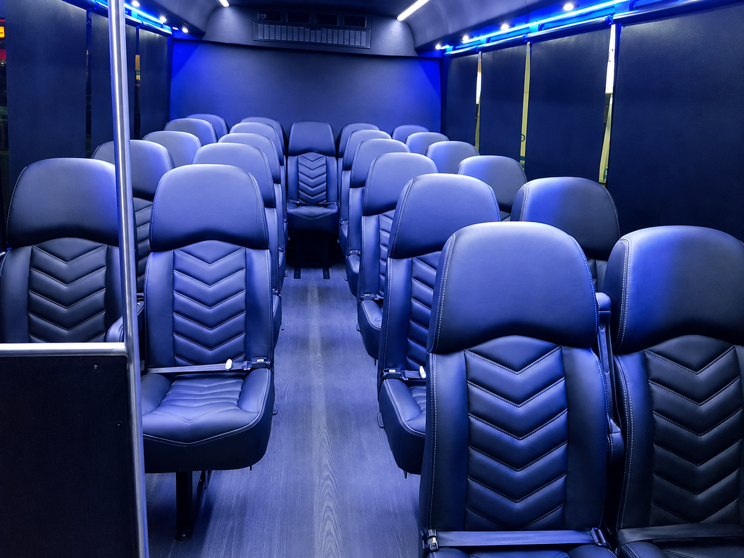 Interior of an EvolveLimo executive motorcoach with reclining seats and ambient lighting